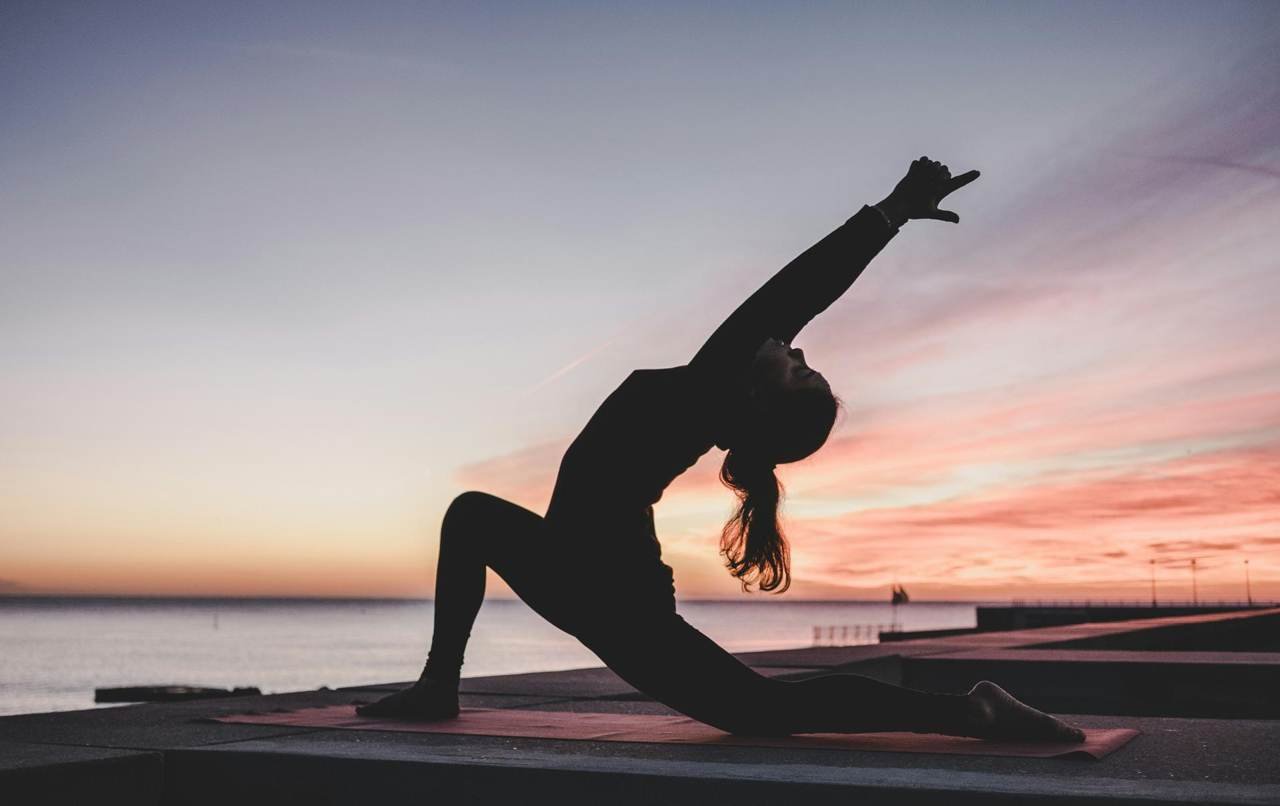 Woman stretching at sunset, mobility and recovery